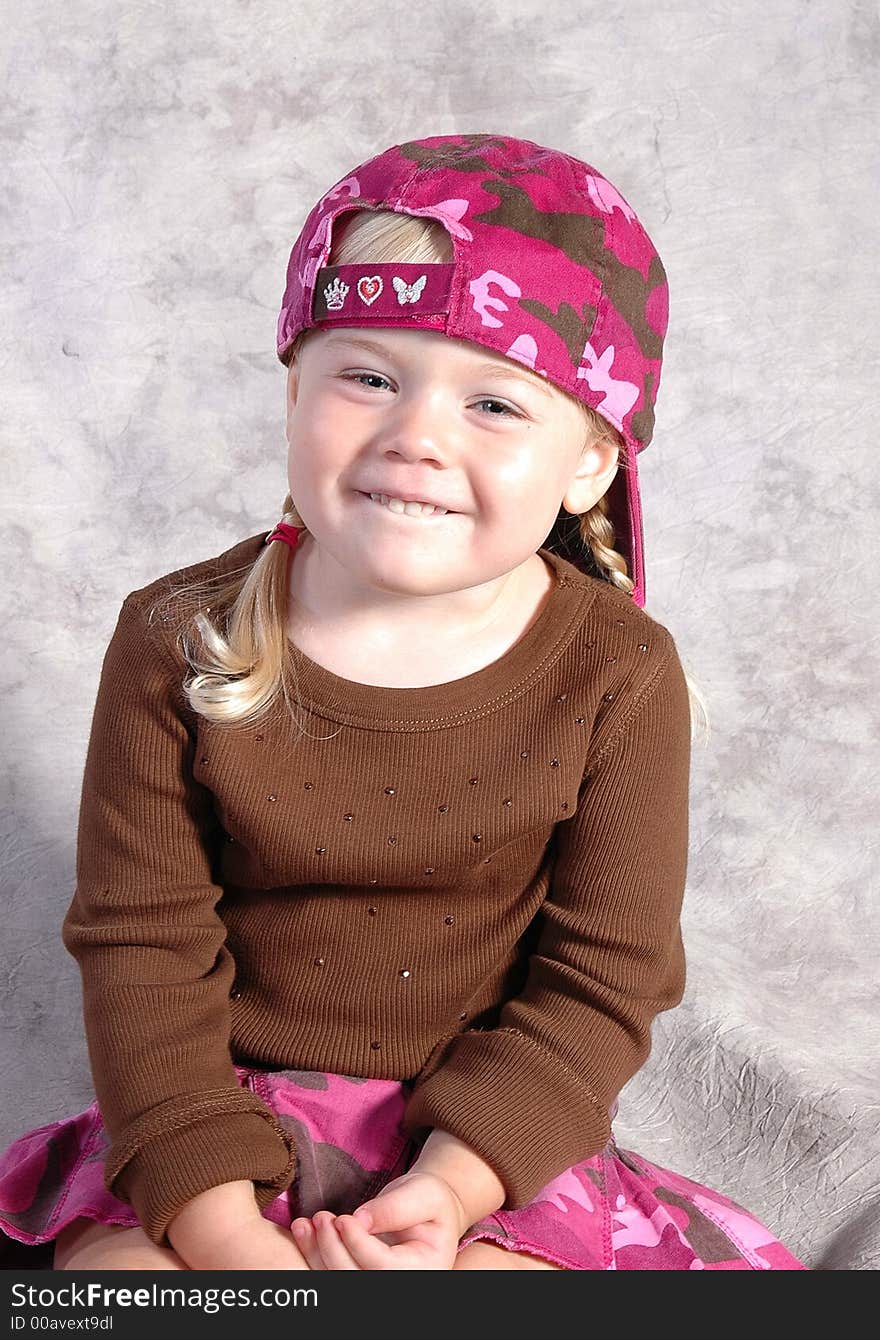 A cute little girl posing on a gray background. A cute little girl posing on a gray background.