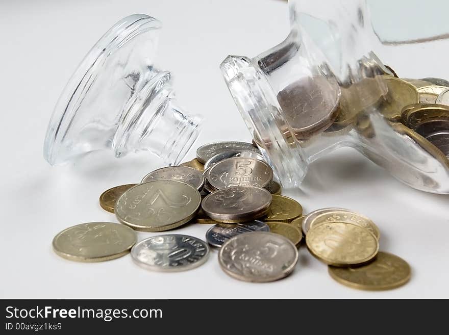 Coins  and glass bottle  on the white. Coins  and glass bottle  on the white