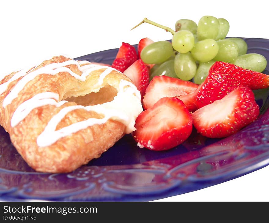 Pastry, grapes and strawberry on a blue plate