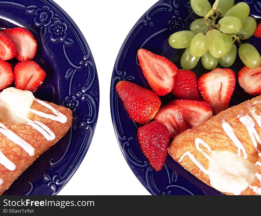 Pastry, grapes and strawberry on two blue plates