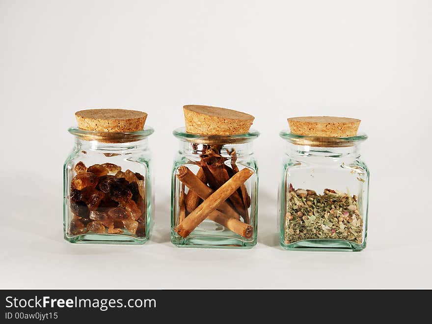 Three glassy boxes with three different spices