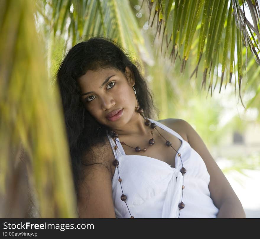 Beautiful girl waiting by a palm tree