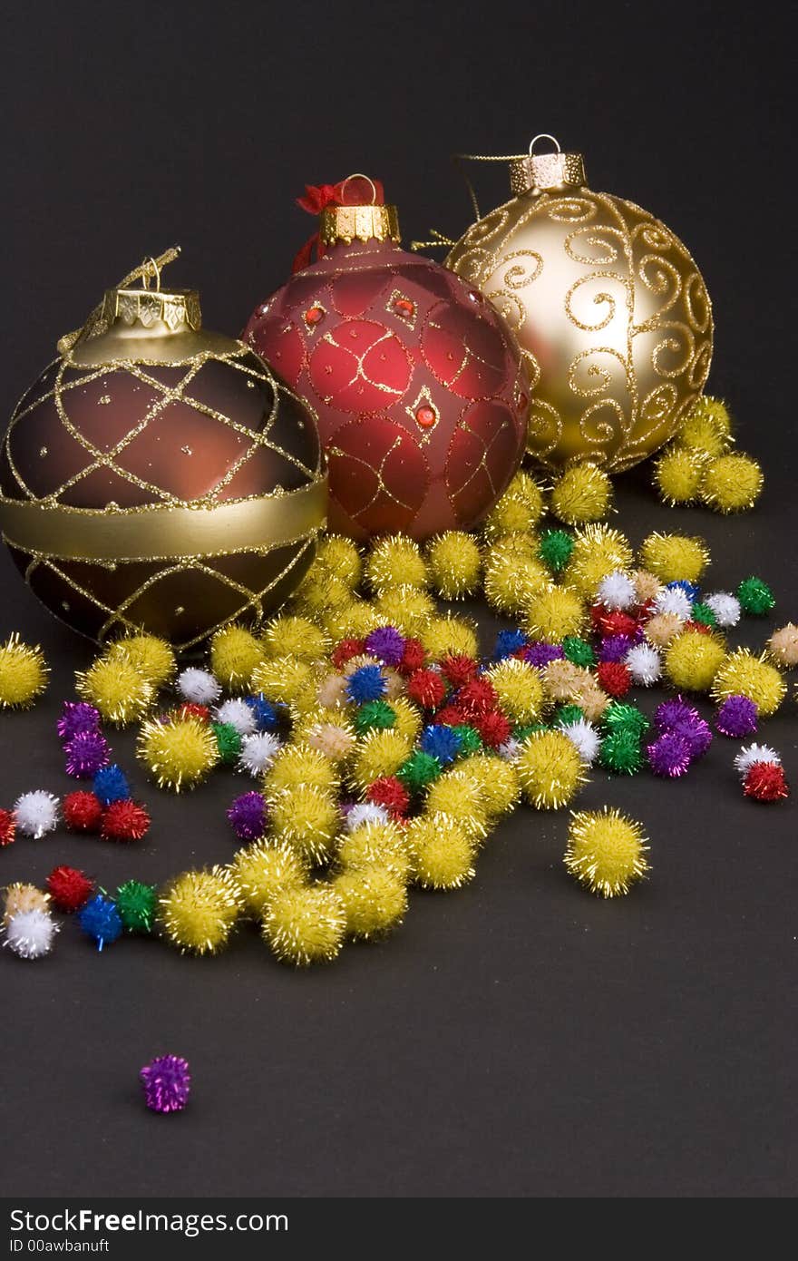 Detail of Christmas balls with bows and gold spike balls against a plain background.