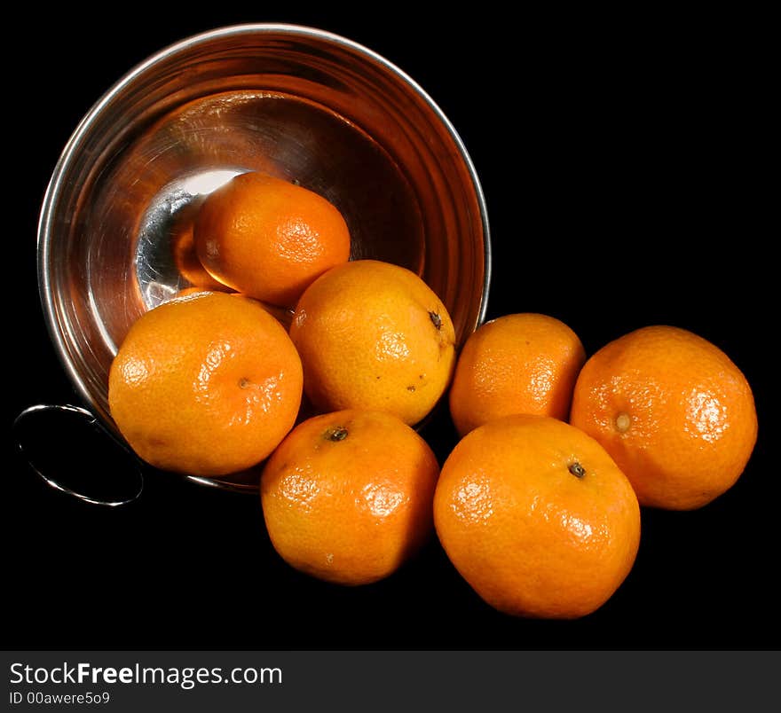 Clementines imported from Spain in a basket on a black background. These are also knows as Satsumas and are grown in southern Louisiana.