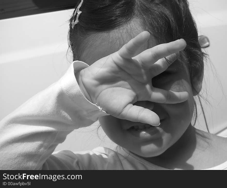 A girl covering her eyes from direct sunlight