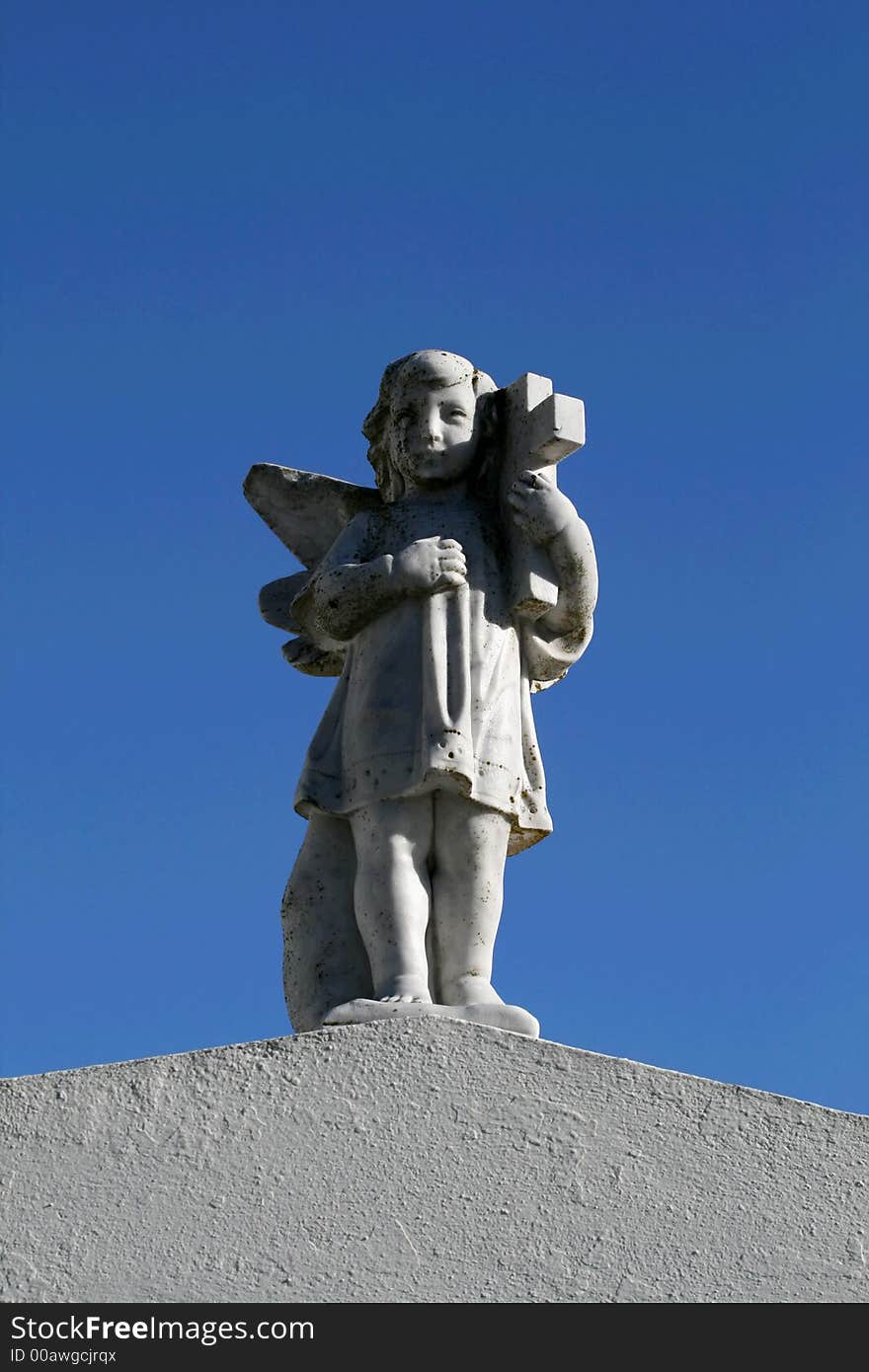 Angel with a cross on top of a tomb