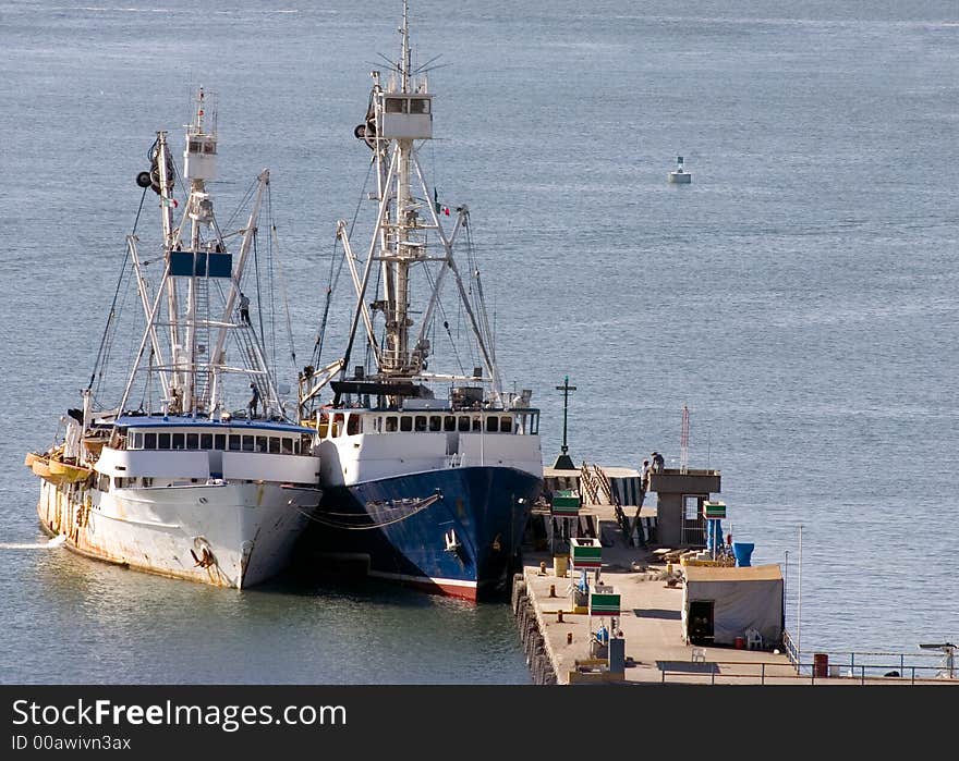 Two rusty old mexican fishing boats tied together