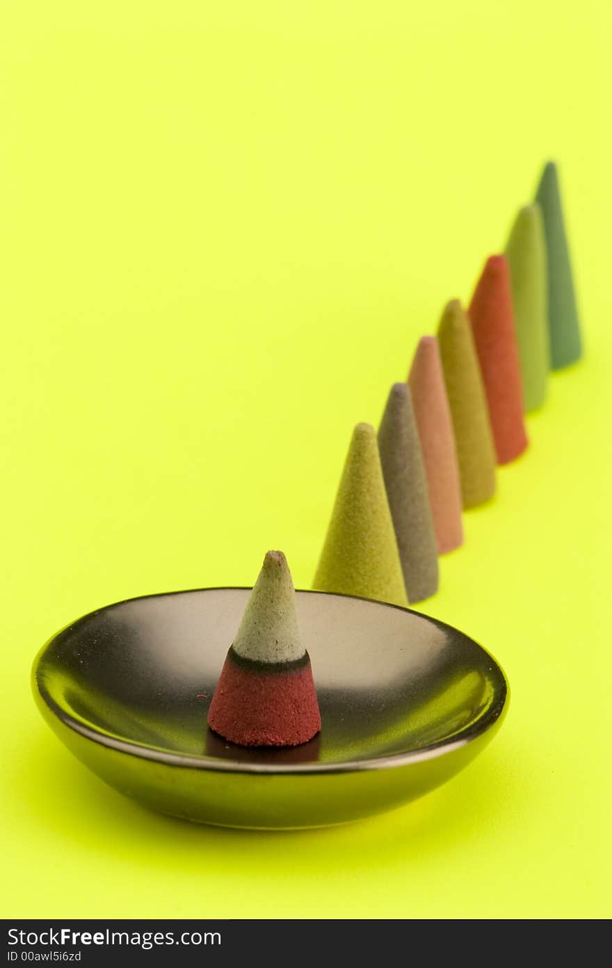 Multi coloured Incense cones against a bright coloured background.