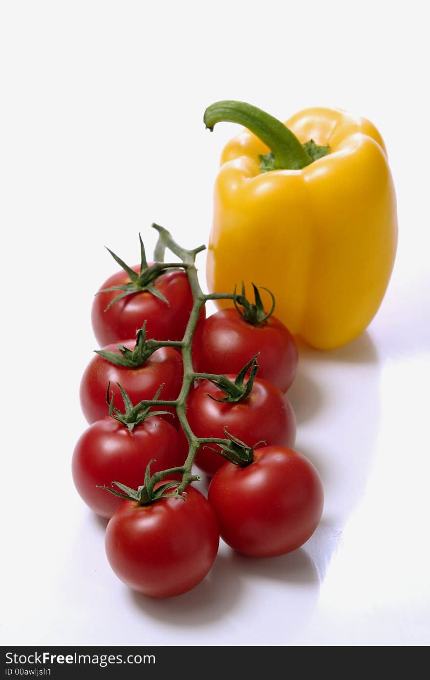 Yellow paprika and red tomatoes over white background. close-up. Yellow paprika and red tomatoes over white background. close-up