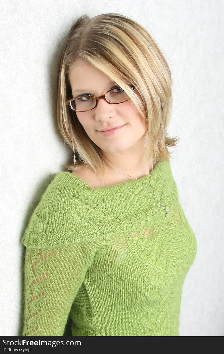 Woman with a shy smile leaning on a wall. Woman with a shy smile leaning on a wall