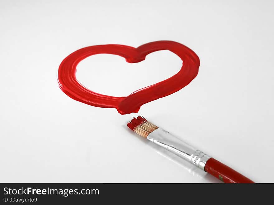 A red painted heart with paintbrush on white. A red painted heart with paintbrush on white