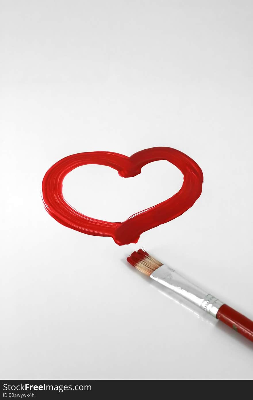 A red painted heart with paintbrush on white. A red painted heart with paintbrush on white