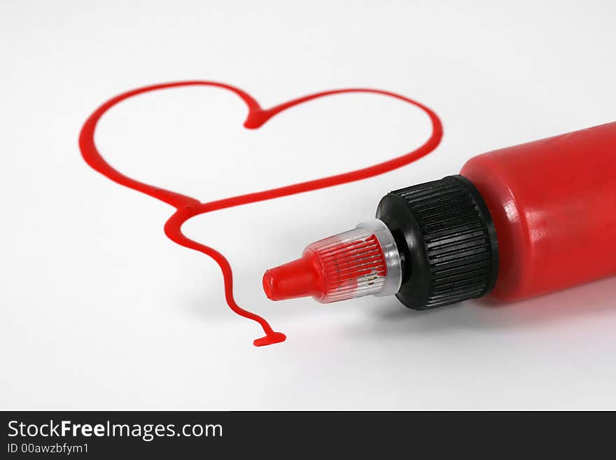 A red painted heart with paint bottle on white. A red painted heart with paint bottle on white