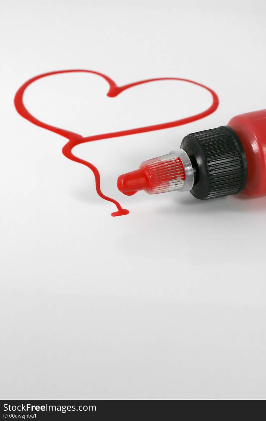 A red painted heart with paint bottle on white. A red painted heart with paint bottle on white