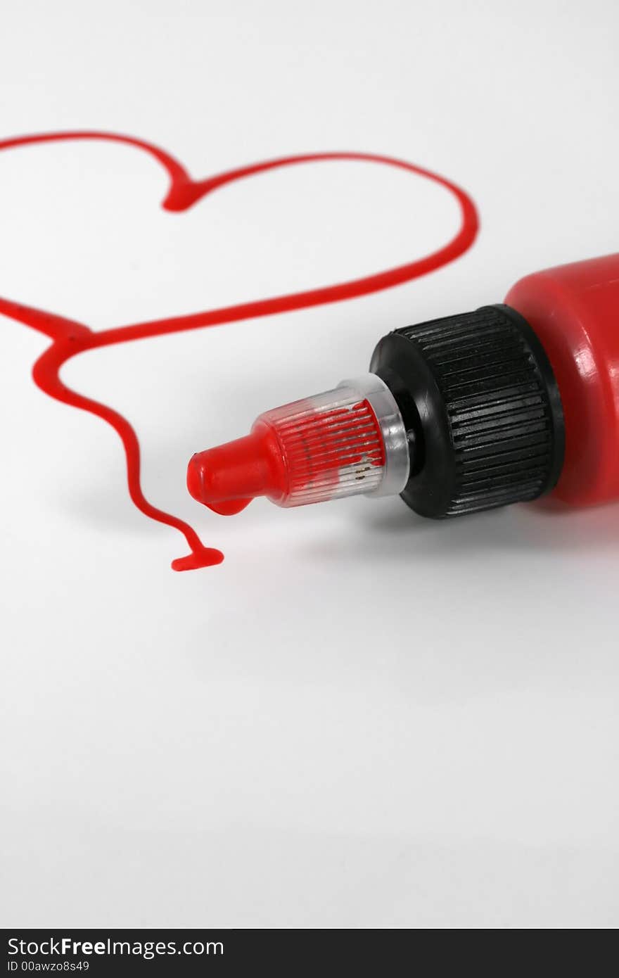 A red painted heart with paint bottle on white. A red painted heart with paint bottle on white