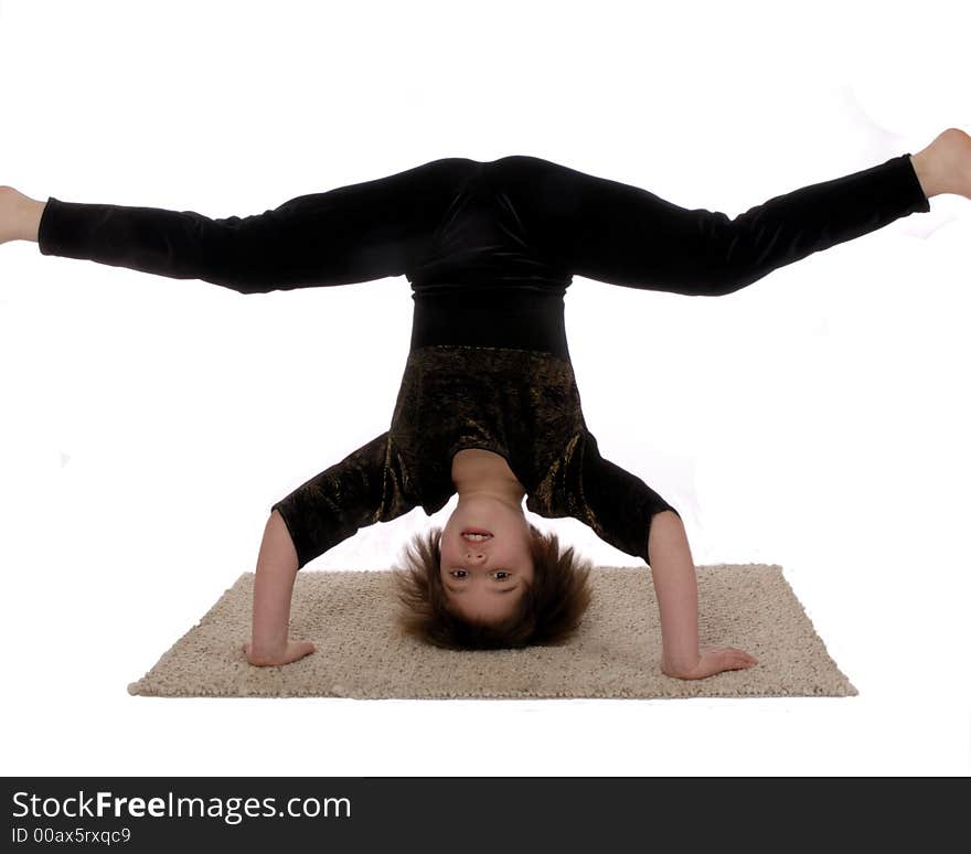 Cute girl in gymnastics suit standing on her head, legs spread horizonatally. Isolated on white. Cute girl in gymnastics suit standing on her head, legs spread horizonatally. Isolated on white.