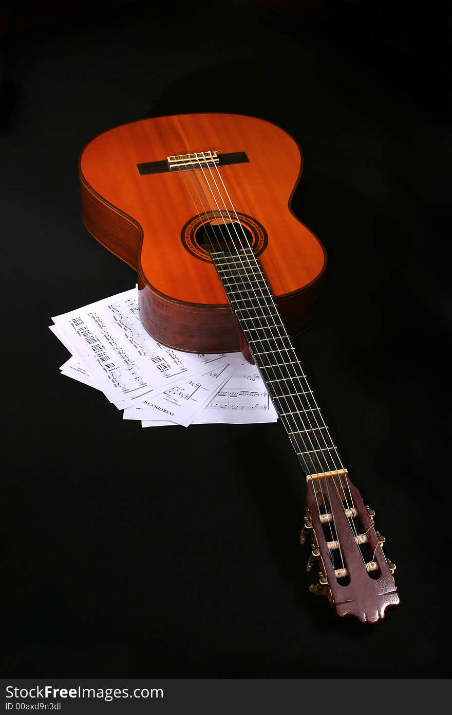 Acoustic guitar with music sheets