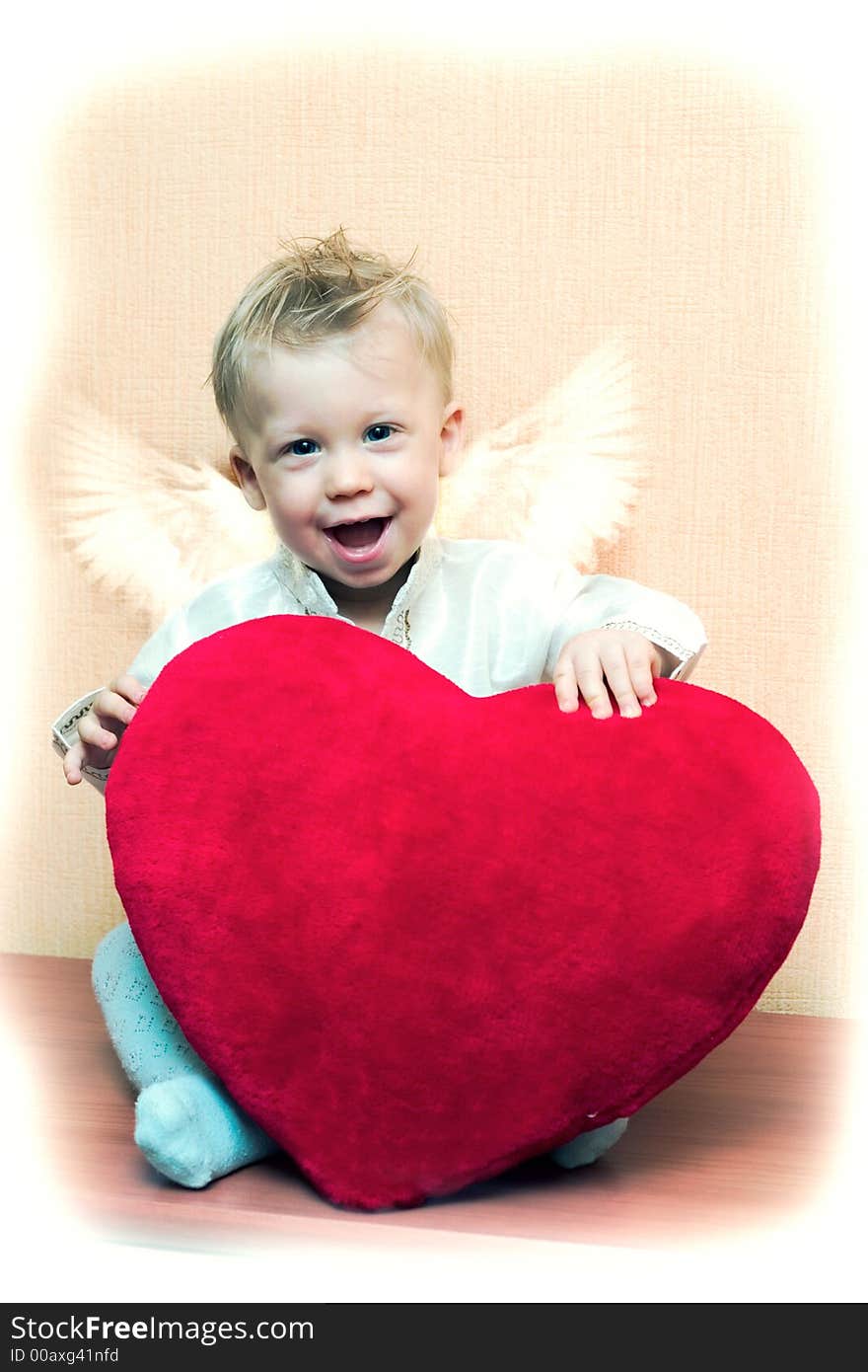 Laughing cute angel boy with big plush red heart. Vintage style card with copy space on the top right corner