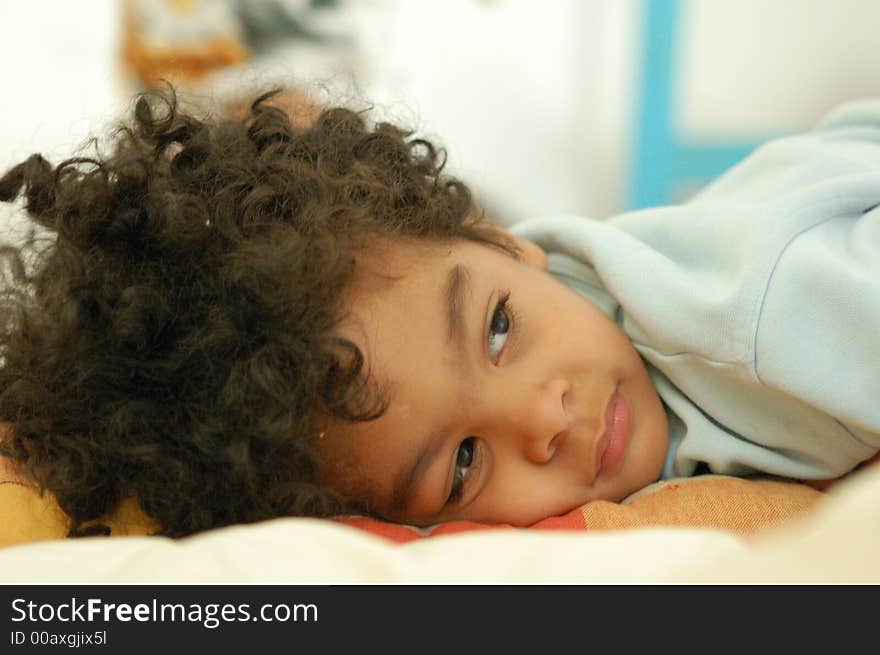 3 year old boy resting on a pillow. Horizontal close up viewing at camera right. 3 year old boy resting on a pillow. Horizontal close up viewing at camera right