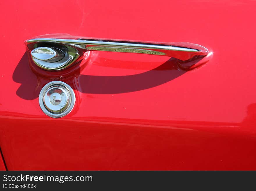 A red car door and handle. A red car door and handle.