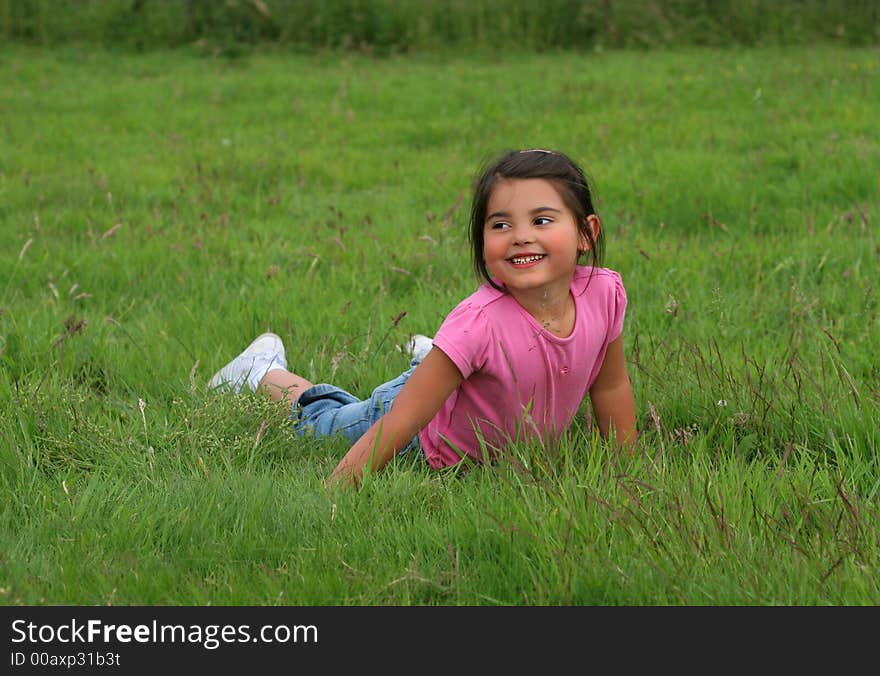 Little girl lying on the grass smiling. Little girl lying on the grass smiling