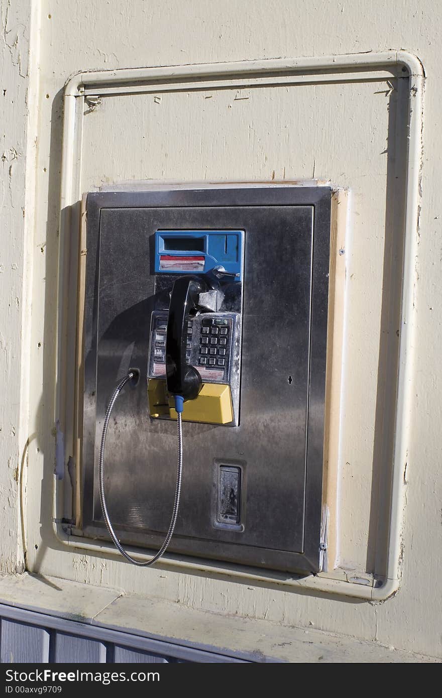 Public phone on a wall of a building. Public phone on a wall of a building