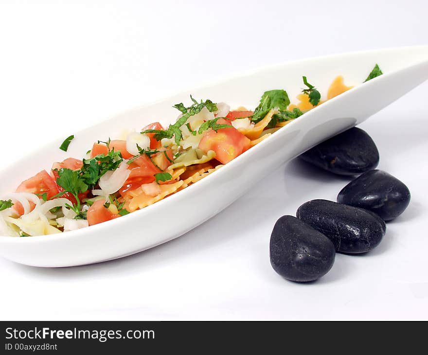 Pasta salad on white bowl with stone decoration