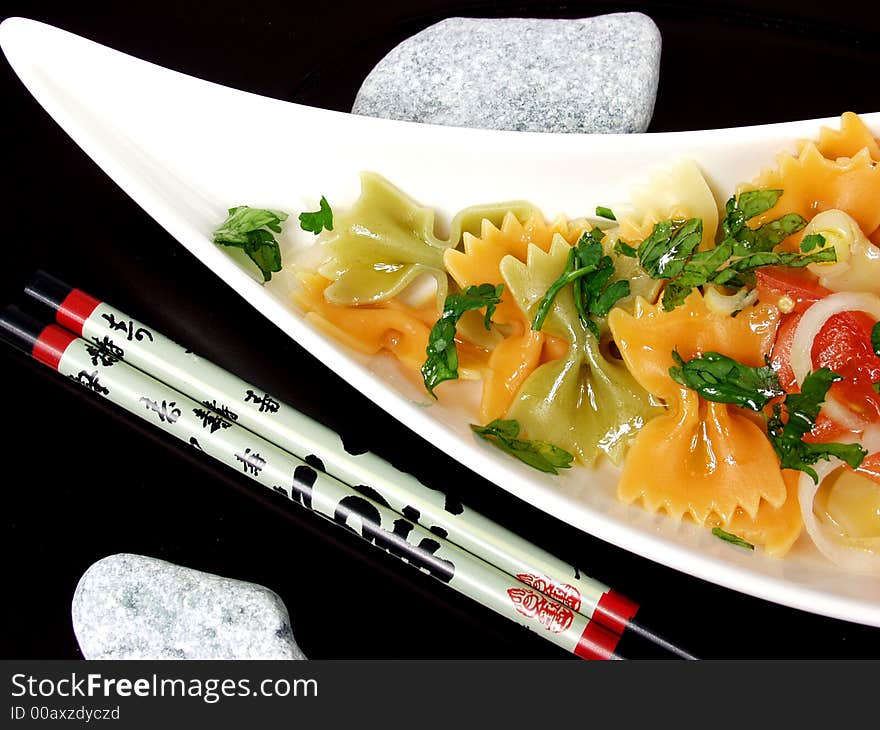 Pasta salad on white bowl with stone decoration