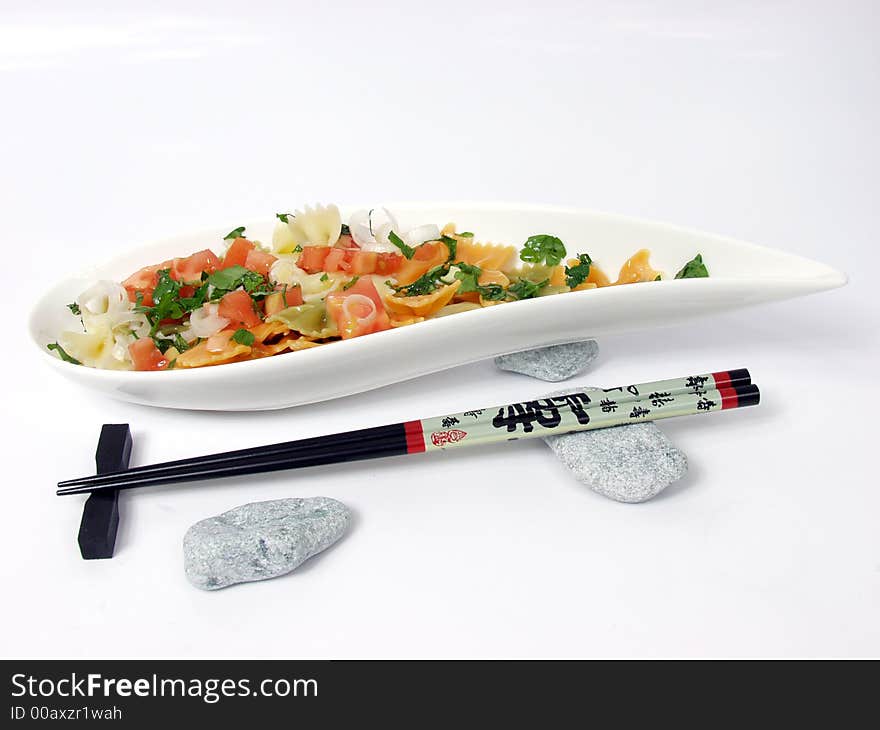 Pasta salad on white bowl with stone decoration