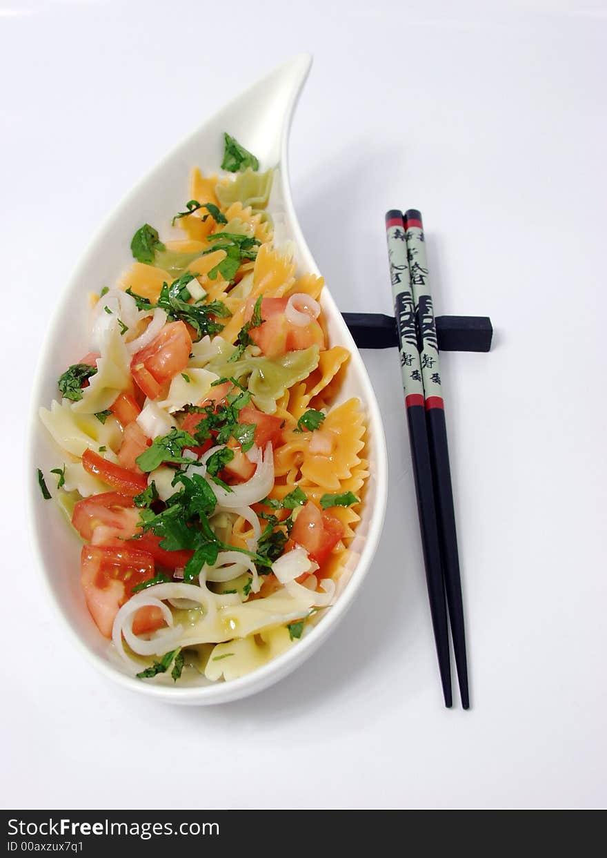 Pasta salad on white bowl with stone decoration