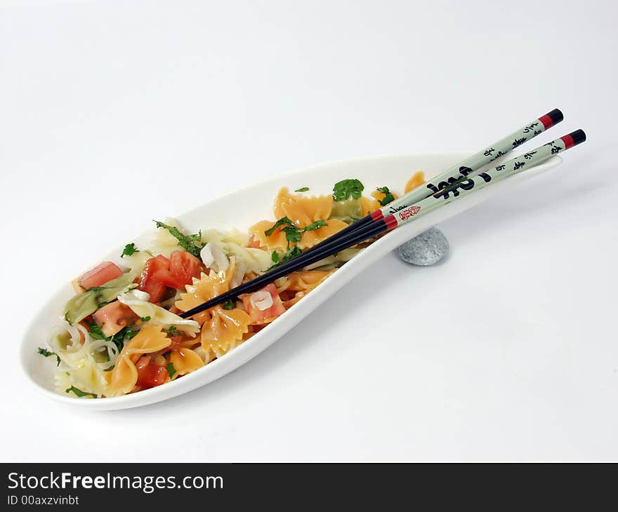 Pasta salad on white bowl with stone decoration