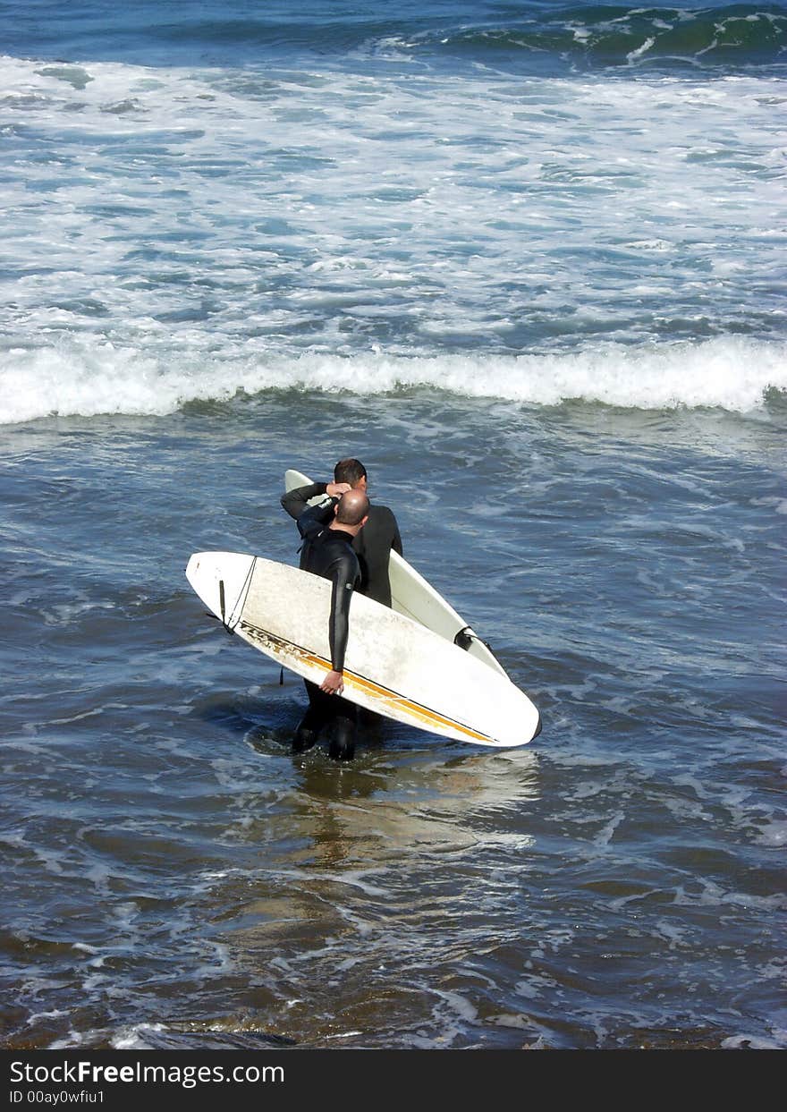 Two surfers men preparin for ride in the weaves