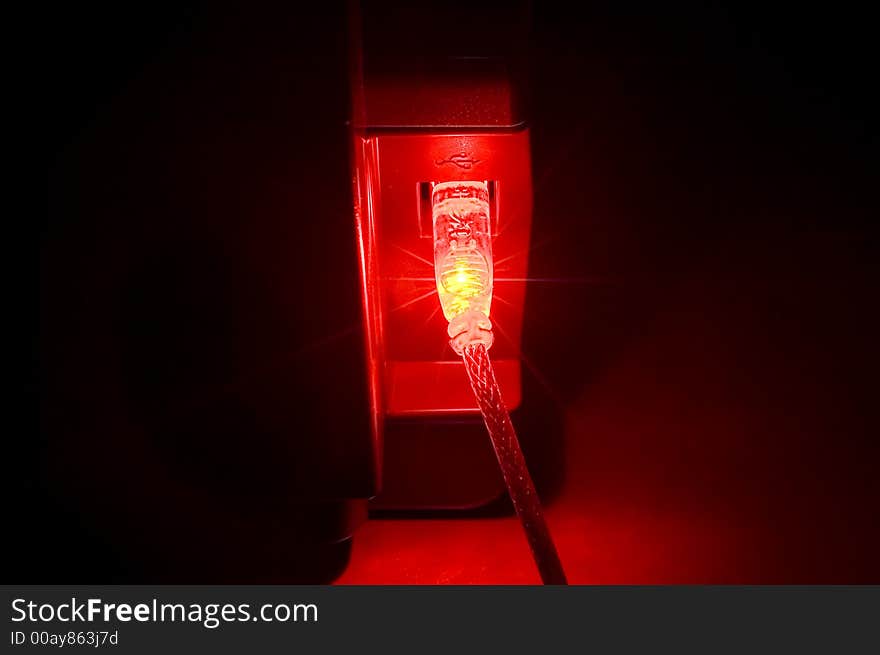 Red usb connector in a darkened room. Red usb connector in a darkened room