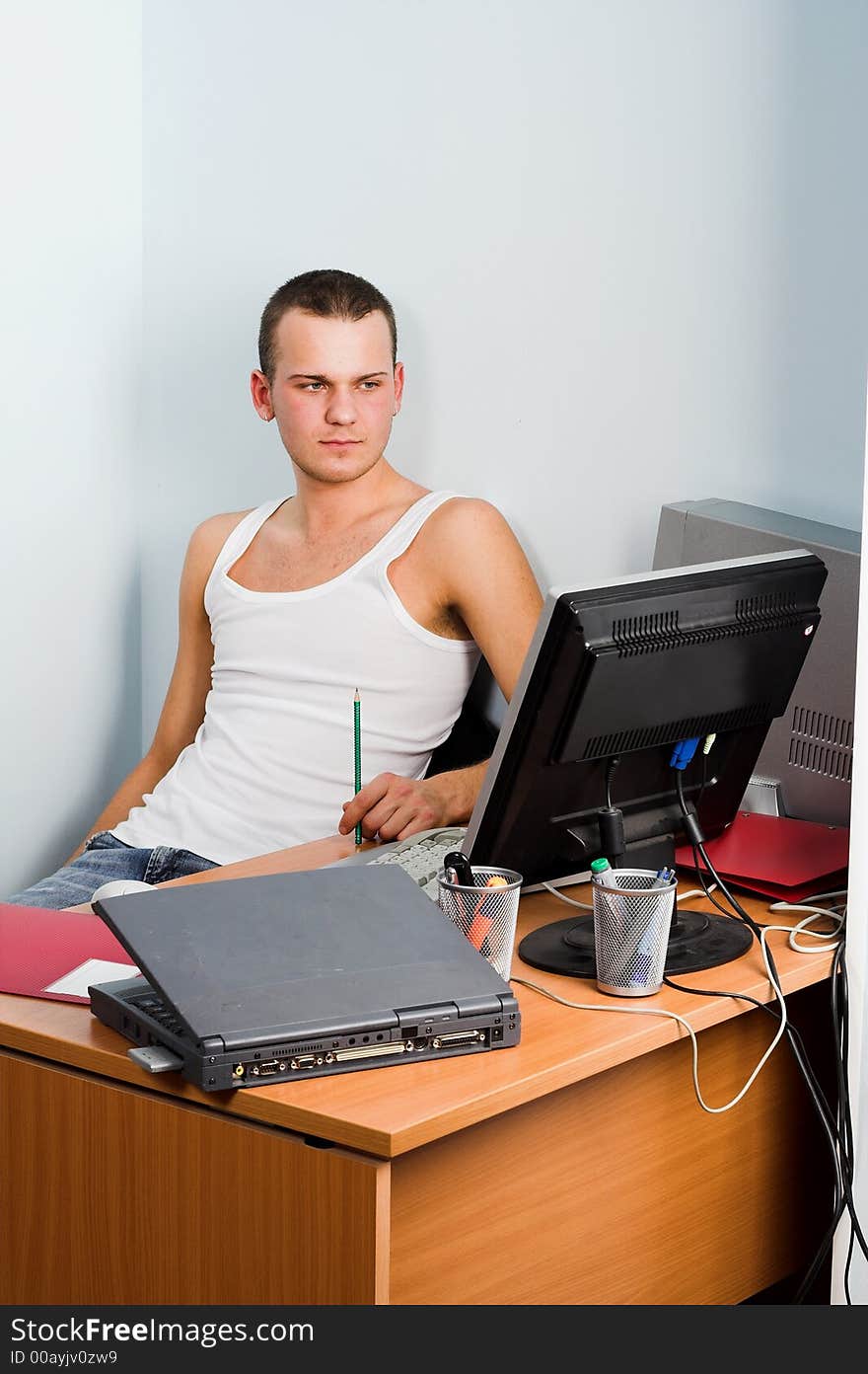 Young businessman works on a laptop computer in the modern office.