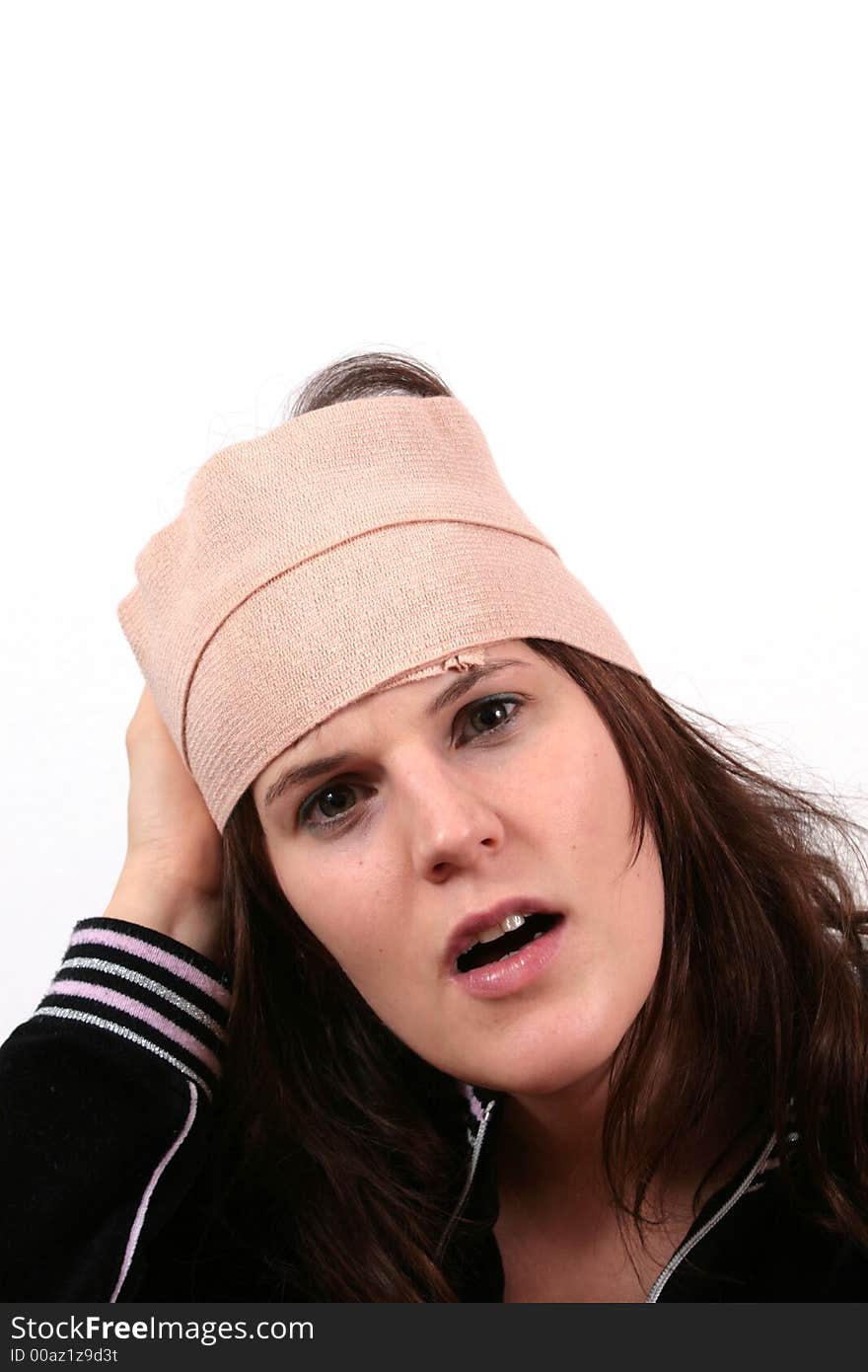 A young woman holds her head with bandage in pain. A young woman holds her head with bandage in pain.