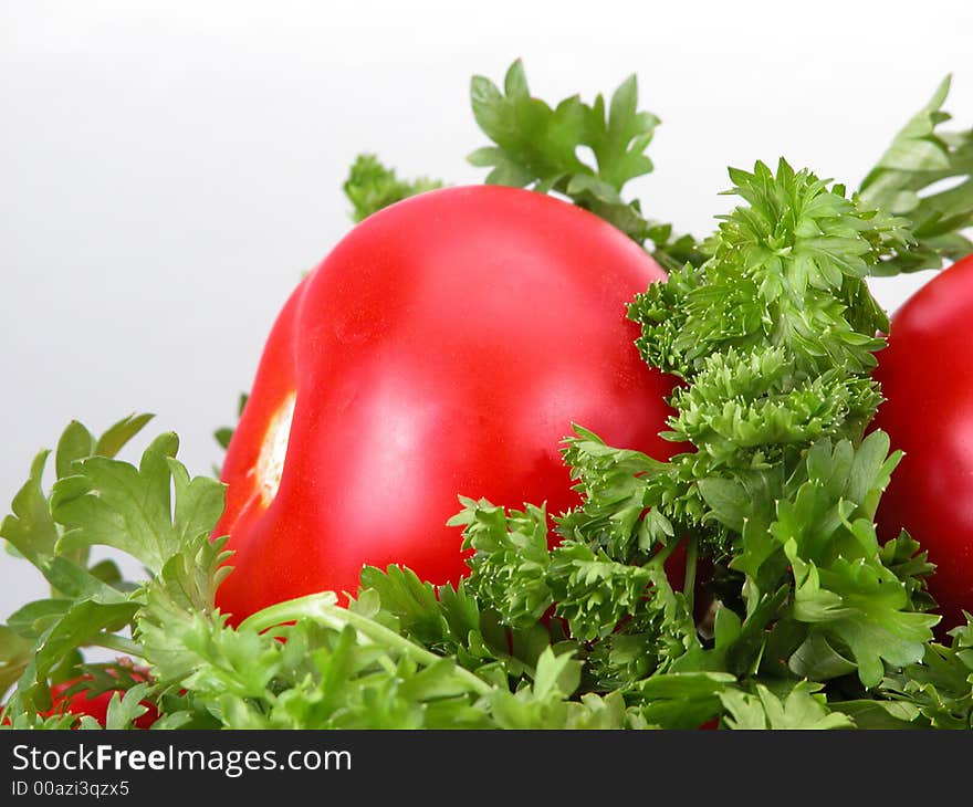 Some tomatoes in a green celery. Some tomatoes in a green celery