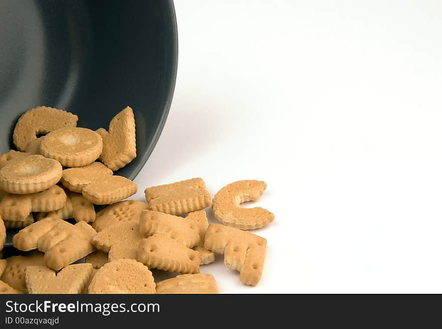 Letter cookies out of a bowl isolated on white background