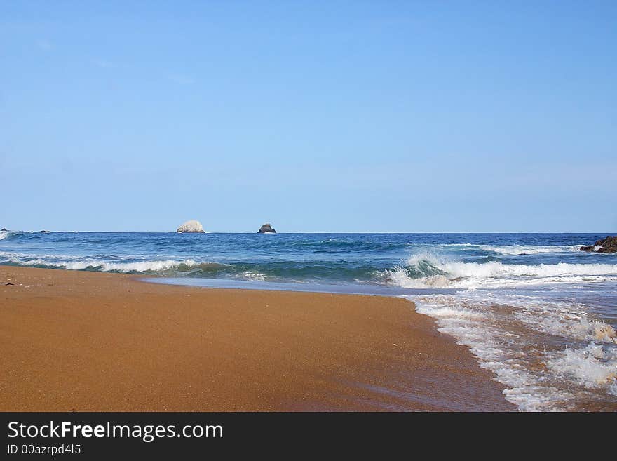 Partial view of a wave and a small island in the bay of San Agustinillo in the southern state of Oaxaca in  Mexico, Latin America. Partial view of a wave and a small island in the bay of San Agustinillo in the southern state of Oaxaca in  Mexico, Latin America