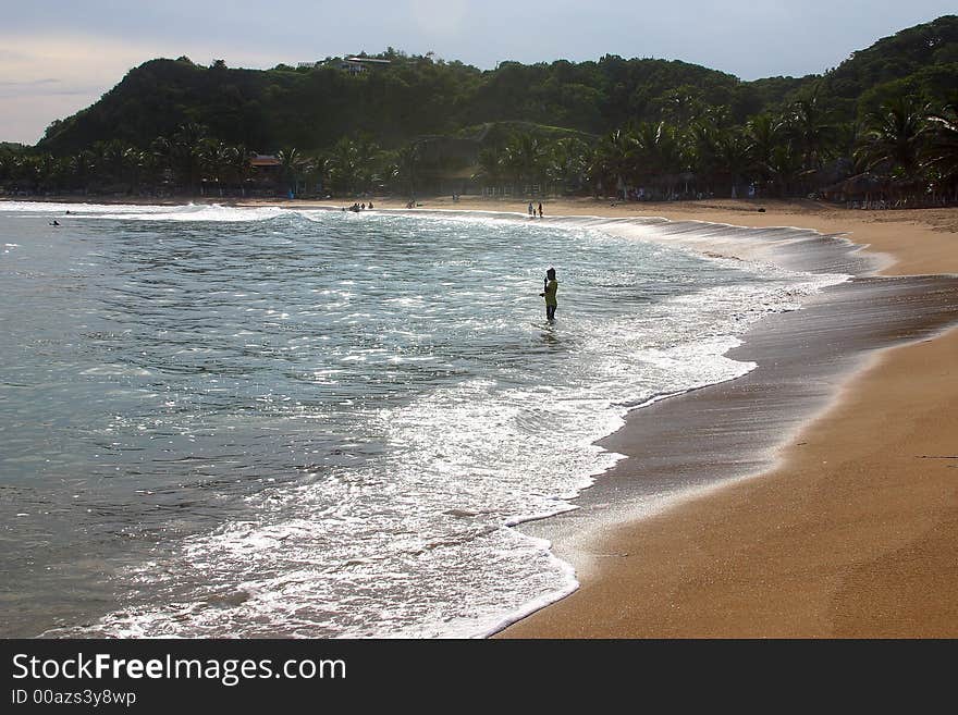 Partial view of a person and a small cliff in the bay of San Agustinillo in the southern state of Oaxaca in  Mexico, Latin America. Partial view of a person and a small cliff in the bay of San Agustinillo in the southern state of Oaxaca in  Mexico, Latin America