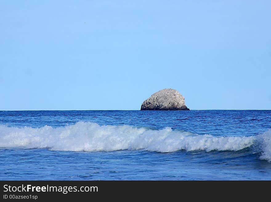 Partial view of a wave and a small island in the bay of San Agustinillo in the southern state of Oaxaca in  Mexico, Latin America. Partial view of a wave and a small island in the bay of San Agustinillo in the southern state of Oaxaca in  Mexico, Latin America