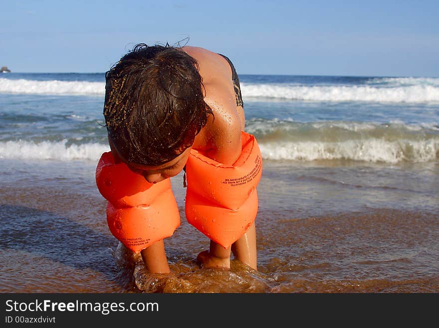 Boy playing sand at the bay of San Agustinillo in the southern state of Oaxaca in Mexico, Latinamerica. Boy playing sand at the bay of San Agustinillo in the southern state of Oaxaca in Mexico, Latinamerica