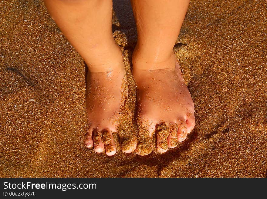 Feet of a little boy in the sand of the bay of San Agustinillo, Oaxaca, Mexico, Latin America. Feet of a little boy in the sand of the bay of San Agustinillo, Oaxaca, Mexico, Latin America