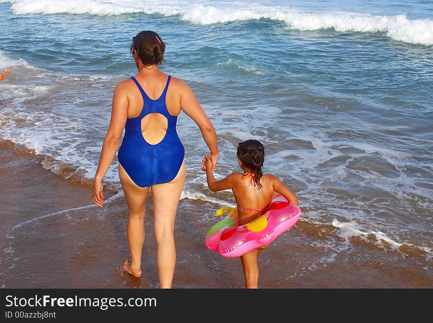 Mother and daughter going to swim at the bay of San Agustinillo in the southern state of Oaxaca in Mexico, Latinamerica. Mother and daughter going to swim at the bay of San Agustinillo in the southern state of Oaxaca in Mexico, Latinamerica