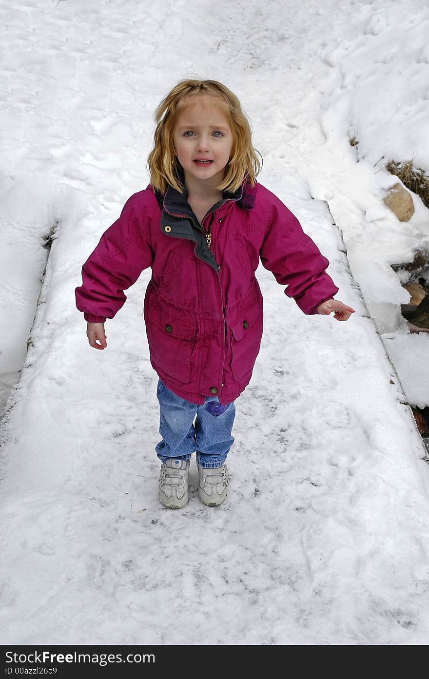 Little girl crossing foot bridge over snow and water. Little girl crossing foot bridge over snow and water