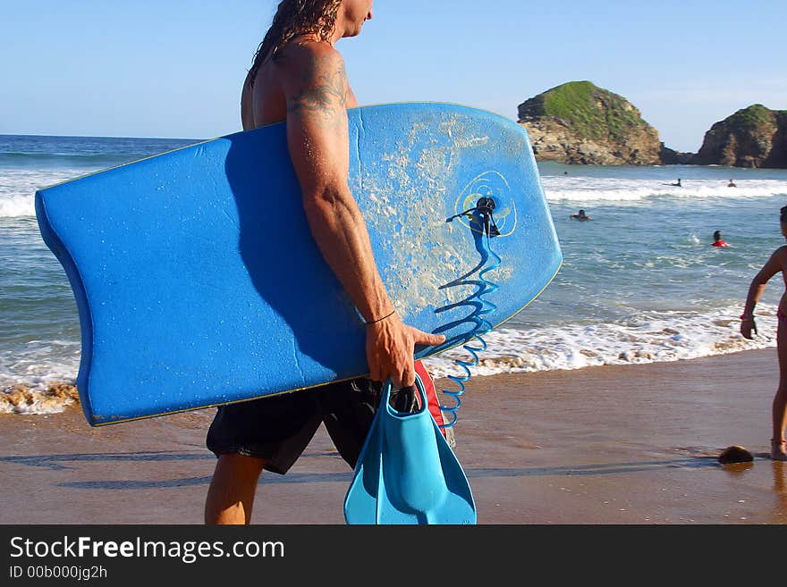 Man carrying his surfboard at the bay of San Agustinillo in the southern state of Oaxaca in Mexico, Latinamerica