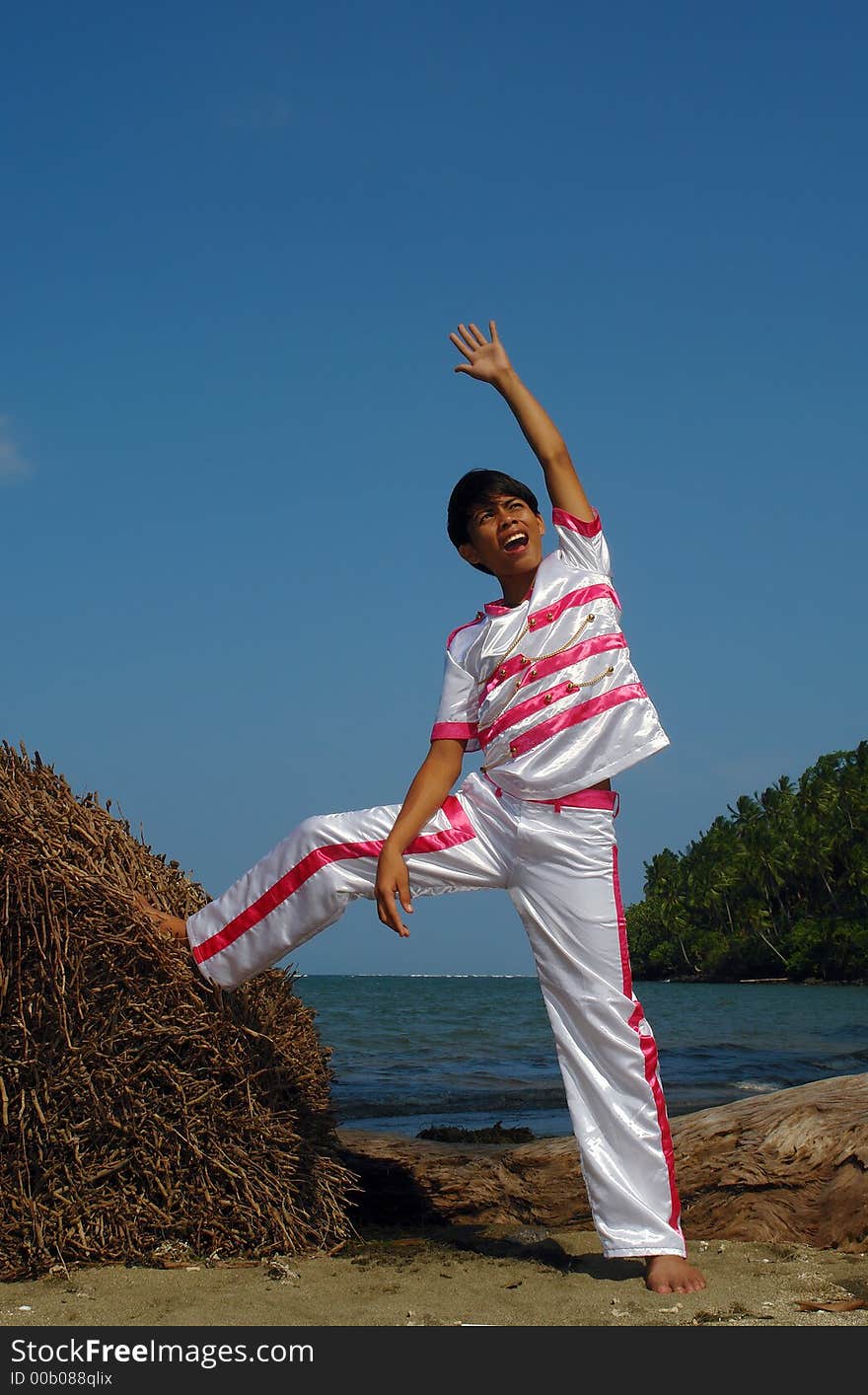 Asian boy in dance costume on the beach.