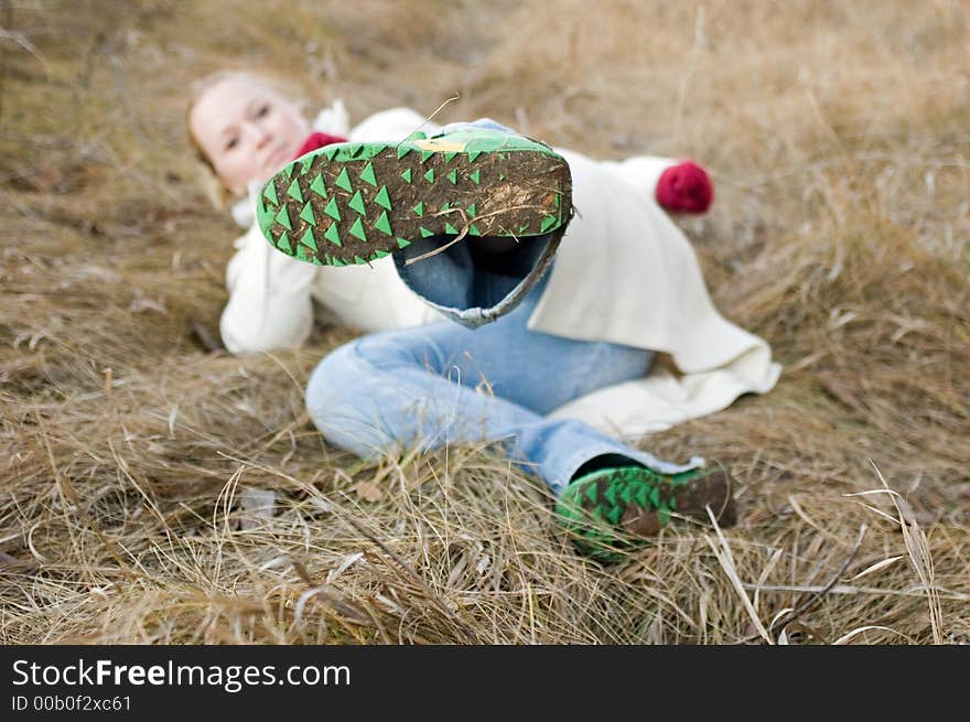 Pretty young lady laying on brown grass having fun. Pretty young lady laying on brown grass having fun.