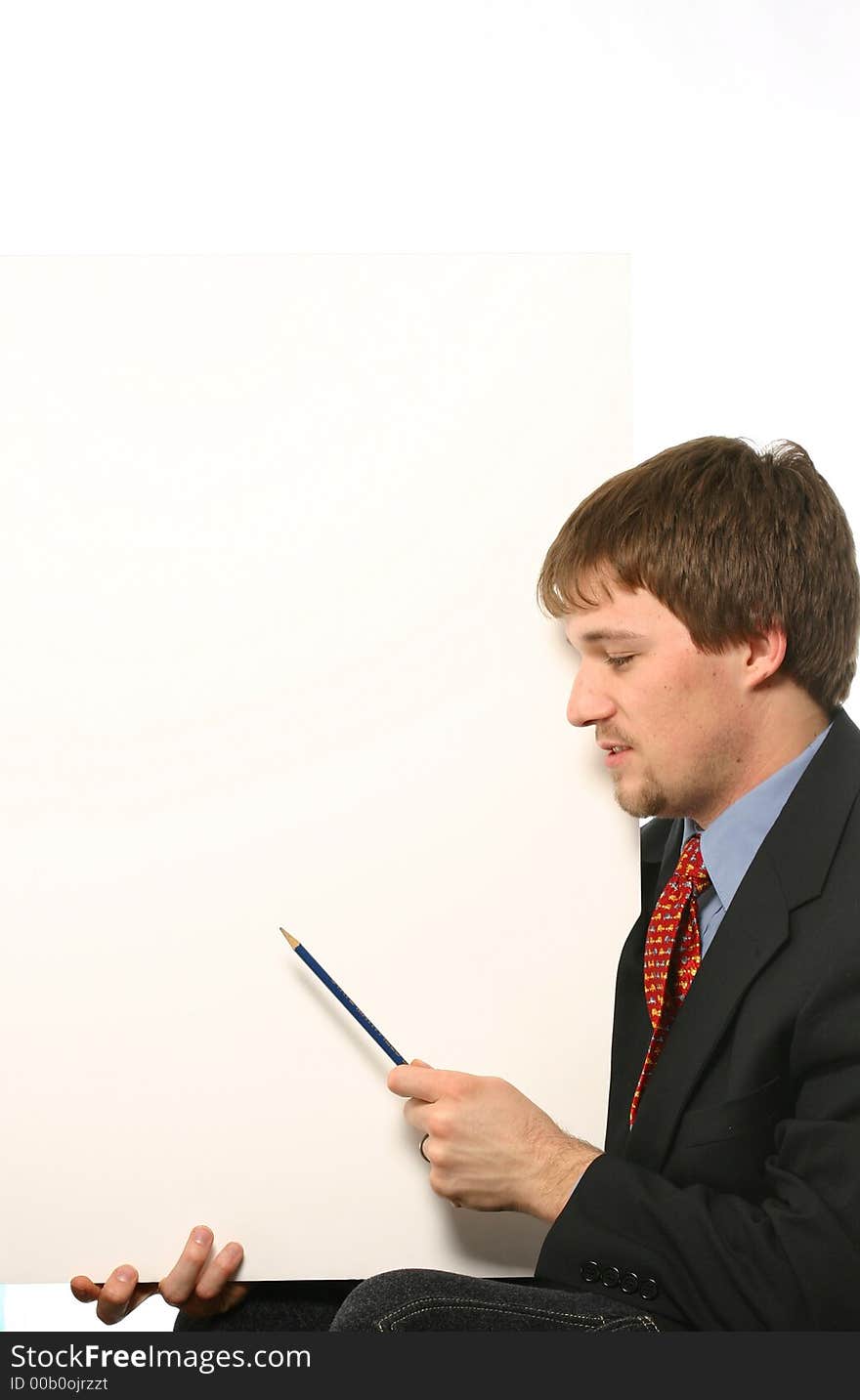 Young man with pencil pointing at board