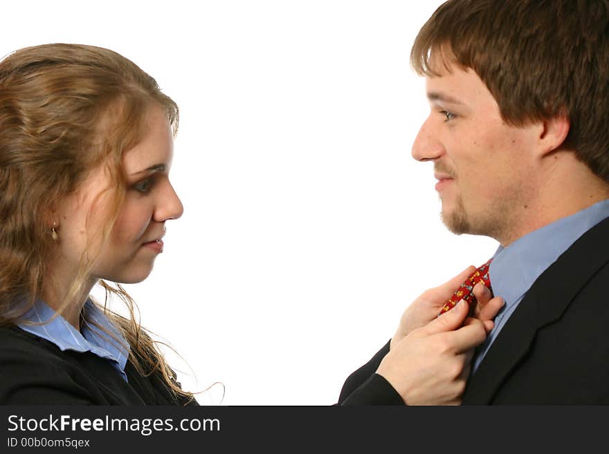 Beautiful young lady fixing man's tie isolated on white space. Beautiful young lady fixing man's tie isolated on white space