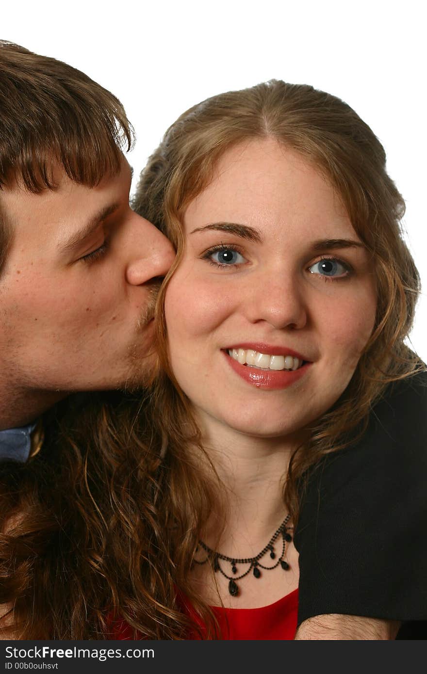 Handsome young man kisses beautiful young lady in a red dress isolated on white space. Handsome young man kisses beautiful young lady in a red dress isolated on white space